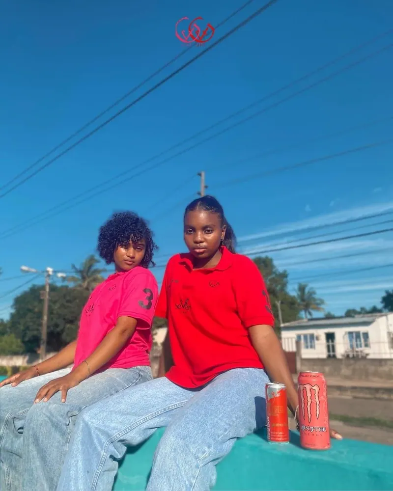 Duas jovens com polos God Seven Line rosa e vermelho